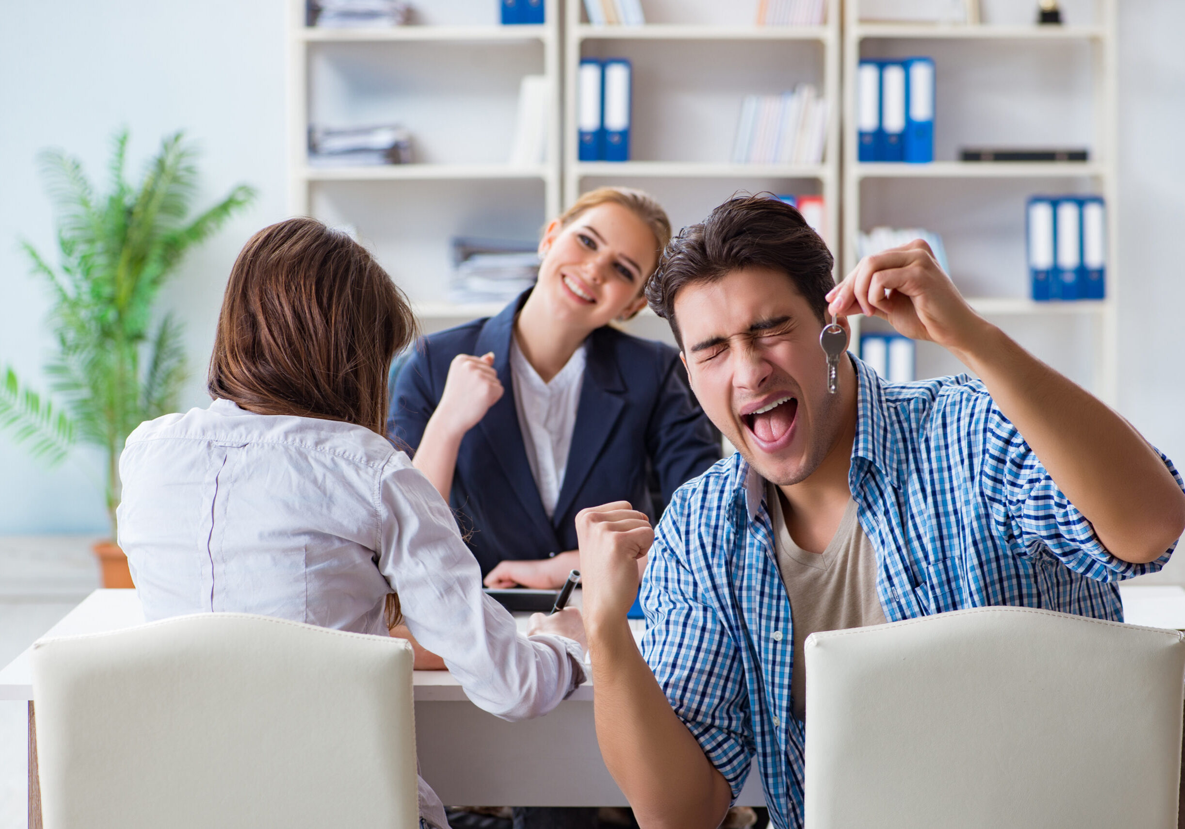 Young family agreeing mortgage contract in the bank for new house