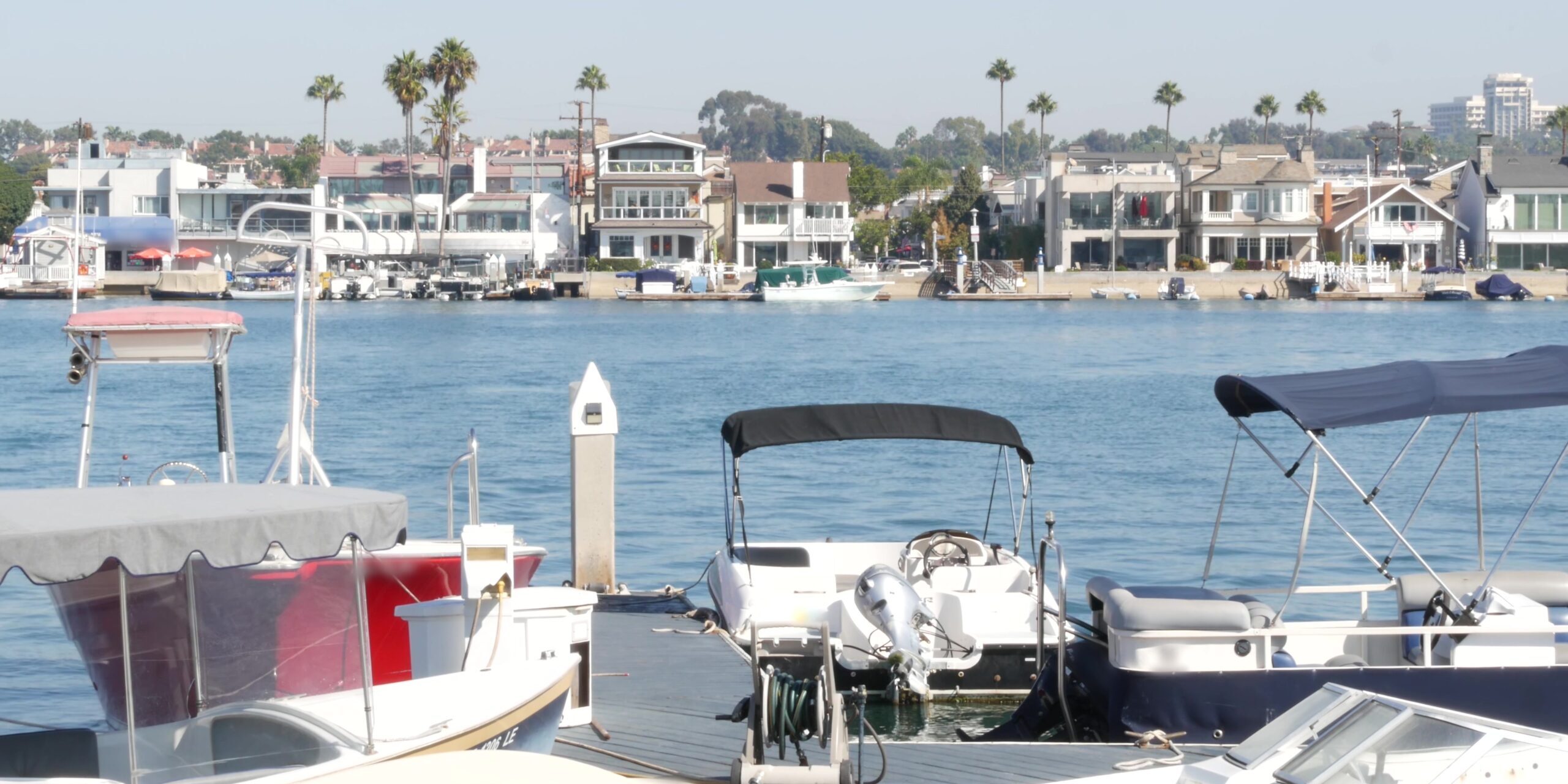 Newport beach harbor, weekend marina resort with yachts and sailboats, Pacific Coast, California, USA. Waterfront luxury suburb real estate in Orange County. Expensive beachfront holiday destination.